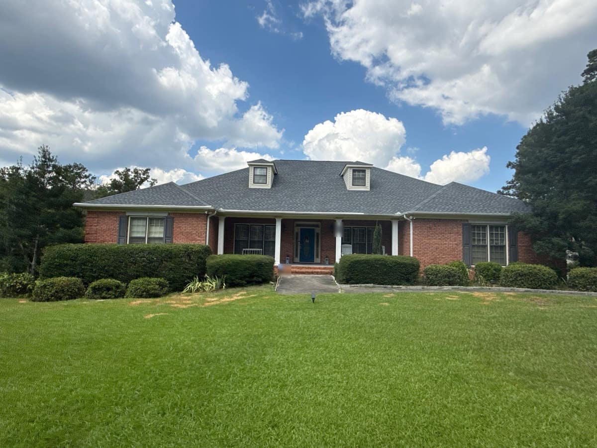 Brick home in McCalla, AL with a new gray hip roof and two cream-sided dormers