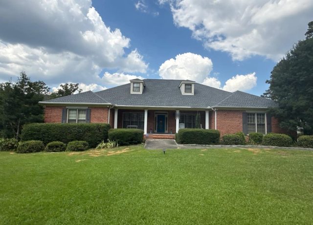 Brick home in McCalla, AL with a new gray hip roof and two cream-sided dormers